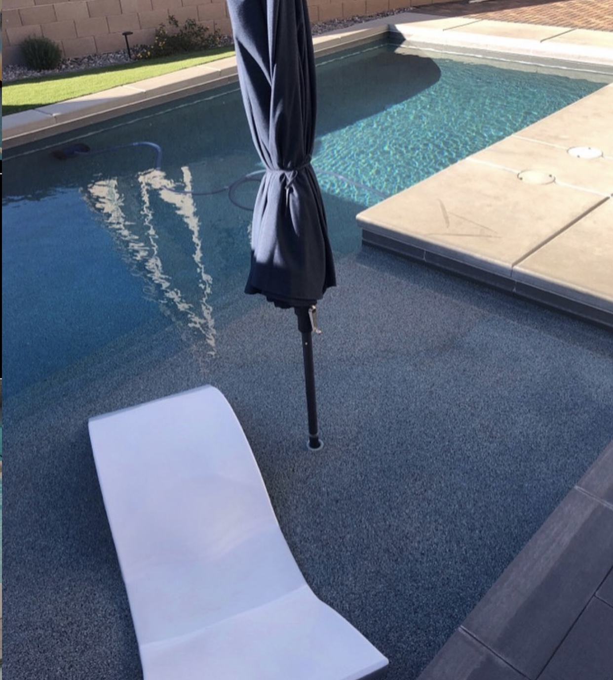 Pool with lounge chair, umbrella and automatic cleaner hose