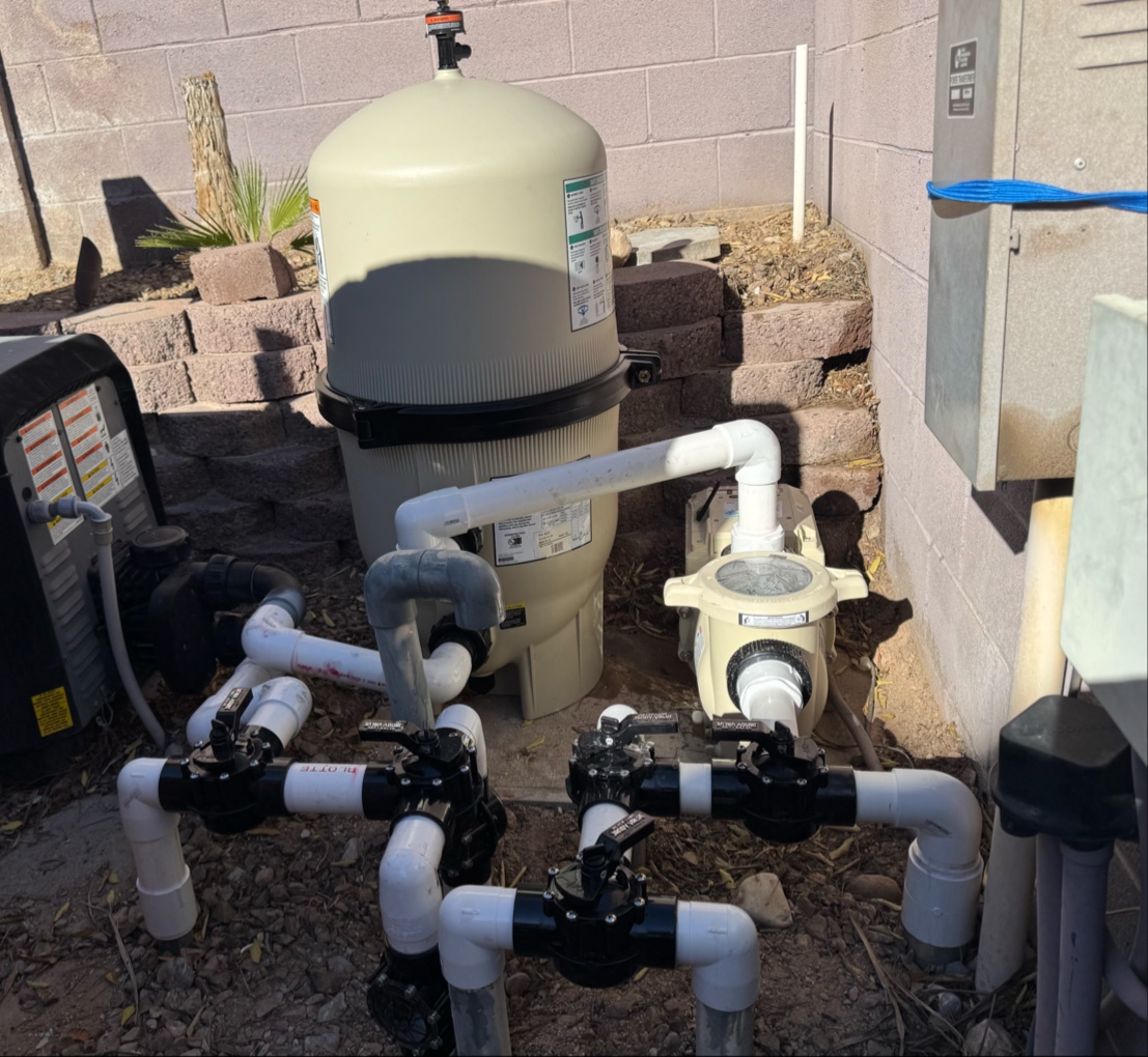 Pool filter tank, pump and valve manifold against block wall
